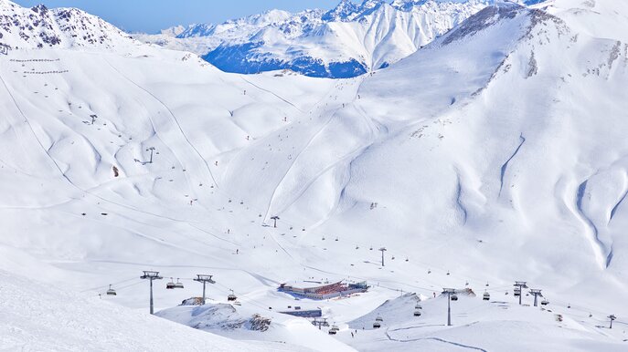 Verschneite Berglandschaft im Skigebiet Masner mit Skipisten, Liften und Skifahrern unter blauem Himmel | © Österreich Werbung