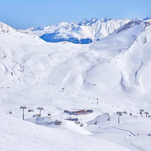 Verschneite Berglandschaft im Skigebiet Masner mit Skipisten, Liften und Skifahrern unter blauem Himmel | © Österreich Werbung