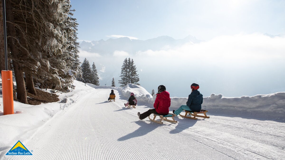 Rodeln mit Kindern auf der neuen Rodelbahn in Fiss mit Neuschnee auf den Bäumen und Sonnenschein in Serfaus-Fiss-Ladis, Tirol, Österreich | © Serfaus-Fiss-Ladis Marketing GmbH | Andreas Kirschner