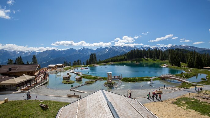 Blick auf den Högsee und den Hög Adventure Park in Serfaus-Fiss-Ladis mit Spielstationen, Holzbrücken und umliegender Alpenkulisse | © Serfaus-Fiss-Ladis Marketing GmbH | Andreas Krischner