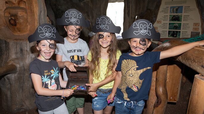 Vier Kinder mit Piratenhüten und Gesichtsbemalung halten eine Schatztruhe voller Süßigkeiten in Serfaus-Fiss-Ladis | © Andreas Kirschner