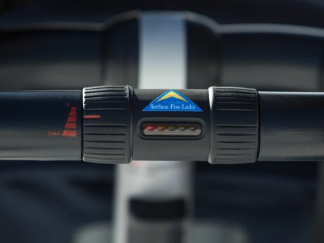 Handle of an e-buggy with the Serfaus-Fiss-Ladis logo | © Serfaus-Fiss-Ladis Marketing GmbH