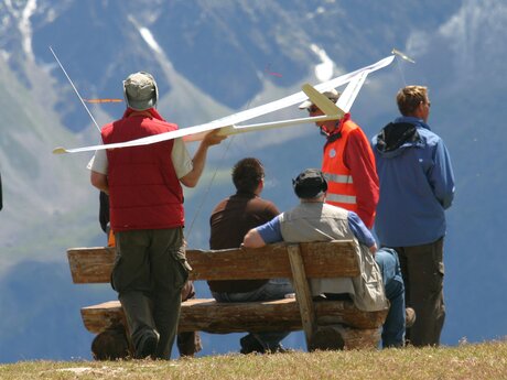 Gruppe von Menschen bei einem Modellflug-Event in Serfaus-Fiss-Ladis, eine Person trägt ein Modellflugzeug auf der Schulter | © Serfaus-Fiss-Ladis Marketing GmbH