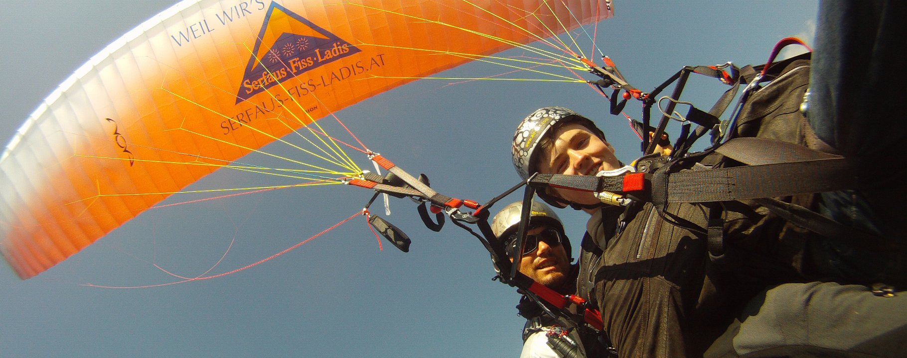 Zwei Personen beim Tandem-Paragleiten mit Schirm "Serfaus-Fiss-Ladis", strahlender Himmel und Flugspaß in Tirol | © Serfaus-Fiss-Ladis Marketing GmbH