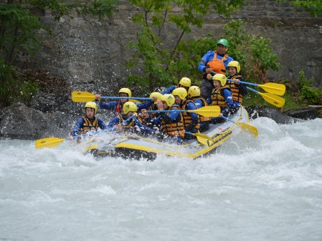 Gruppe in Schlauchbooten beim Wildwasser-Rafting in Tirol, spritzendes Wasser und paddelnde Teilnehmer mit Helmen und Schwimmwesten | © whynot-tirol.com