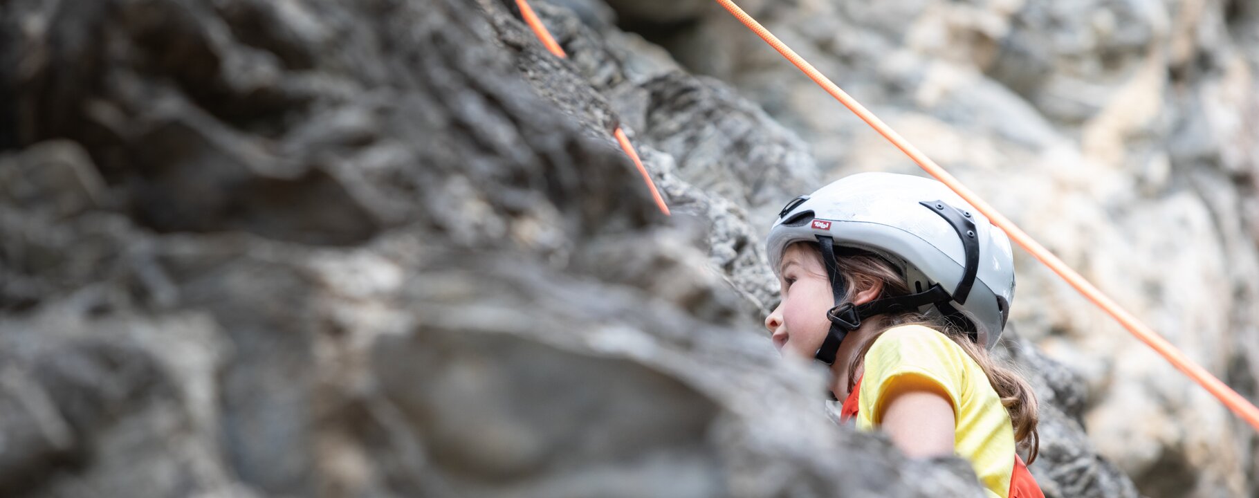 Mädchen mit Kletterhelm an einer Felswand in Serfaus-Fiss-Ladis beim Klettern | © Serfaus-Fiss-Ladis Marketing GmbH | Andreas Kirschner
