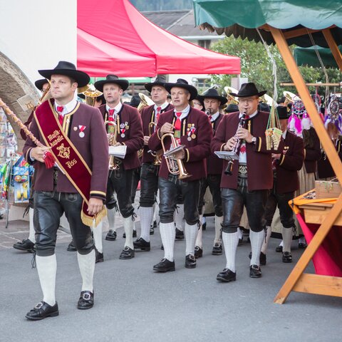 Musicians in traditional attire marching with their instruments through the market area during the Fest am Brunnen in Fiss | © Serfaus-Fiss-Ladis Marketing GmbH | Andreas Kirschner