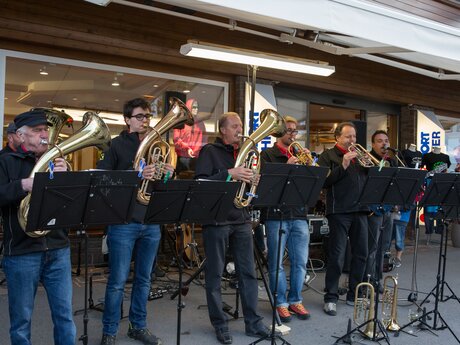 Sechs Musiker mit Blechblasinstrumenten spielen bei einer Outdoor-Veranstaltung vor einem Sportgeschäft | © Serfaus-Fiss-Ladis Marketing GmbH | Andreas Kirschner