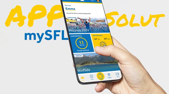 Serfaus-Fiss-Ladis App Darstellung auf einem Smartphone, das von einer Hand gehalten wird | © Serfaus-Fiss-Ladis Marketing GmbH