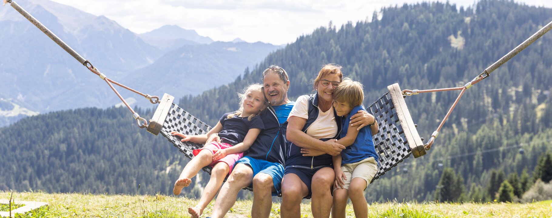 Familie auf einer Hängematte bei einem Bach in Serfaus-Fiss-Ladis | © Serfaus-Fiss-Ladis Marketing GmbH | Daniel Zangerl