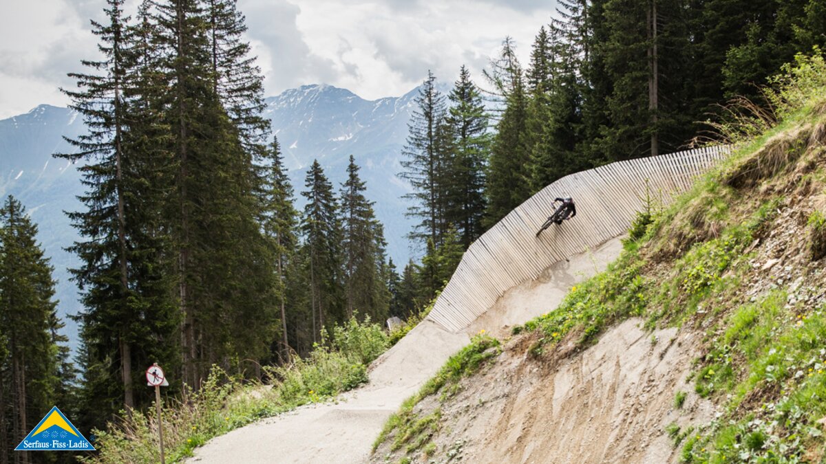 Celine mit dem Downhillbike im Bikepark Serfaus Fiss Ladis in Tirol auf einem Holzsteg | © Socialweb