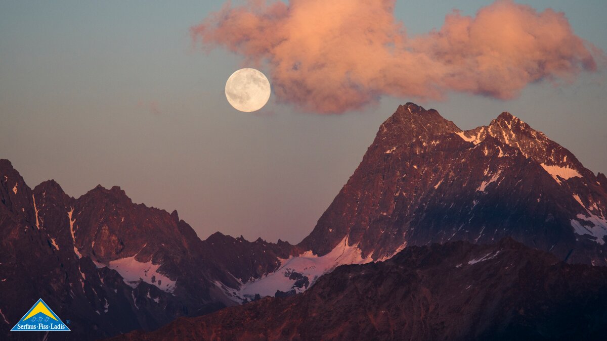 Der Mond ragt zwischen den Bergspitzen in Serfaus Fiss Ladis in Tirol heraus. | © Socialweb