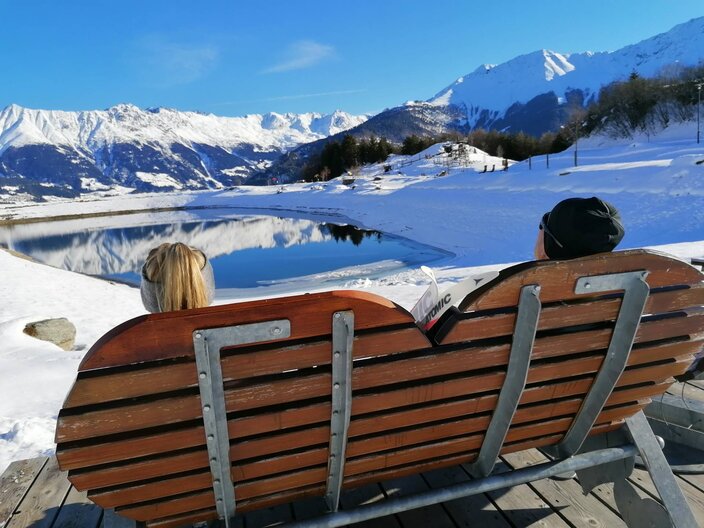 Auf dieser Bank werden Winterwanderer und Langläufer bei einer Rast mit einem fabelhaften Ausblick auf den Wolfsee inmitten der familienfreundlichen Bergwelt von Serfaus-Fiss-Ladis belohnt. | © Serfaus-Fiss-Ladis Marketing GmbH