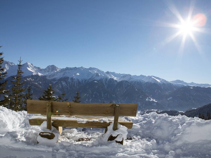 Eine Aussichtsbank mit tollem Rundumblick auf die Bergwelt von Serfaus-Fiss-Ladis auf dem Panorama-Genussweg, sehr beliebt bei Winterwanderern  | © Serfaus-Fiss-Ladis Marketing GmbH I Andreas Kirschner