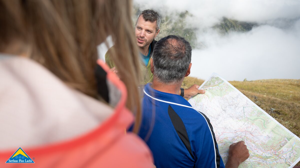 Gruppe studiert Wanderkarte Orientierung in den Alpen Wanderkarte von Serfaus-Fiss-Ladis in Tirol | © Serfaus-Fiss-Ladis Marketing GmbH | Andreas Kirschner