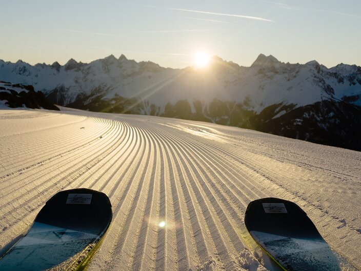 Skispitzen auf einer frisch präparierten Piste bei Sonnenaufgang am Schönjoch im Skigebiet Serfaus-Fiss-Ladis in Tirol | © Serfaus-Fiss-Ladis Marketing GmbH
