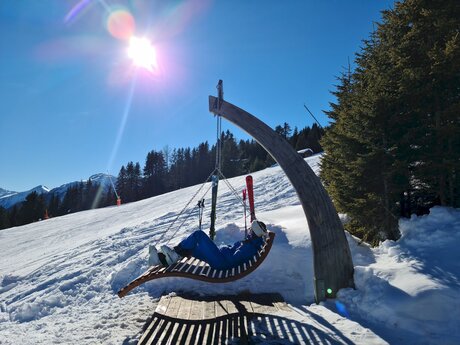 Frau liegt in einer Hängeliege Wohlfühlstation im Skigebiet Serfaus-Fiss-Ladis in Tirol | © Serfaus-Fiss-Ladis Marketing GmbH