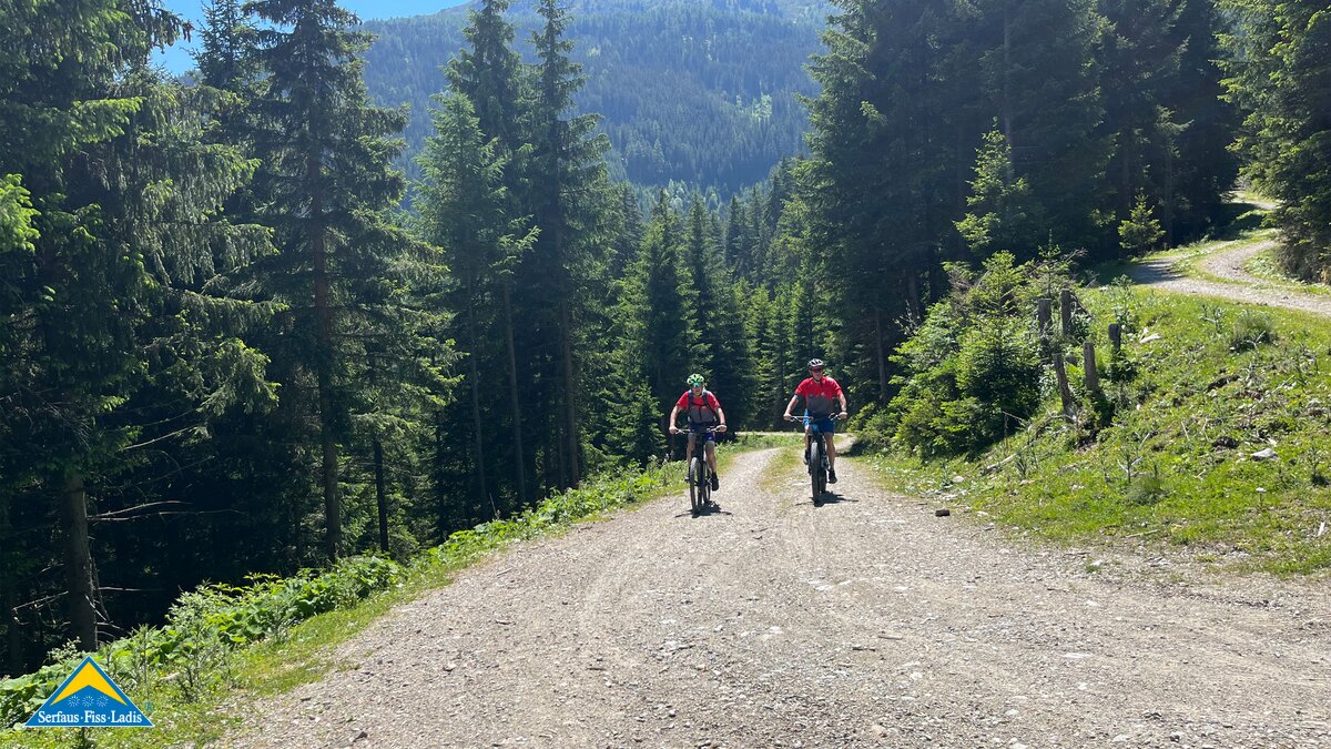 Ein sonniger und breiter Radweg führt bei Bike Everest Tirol in Richtung Schöngampalm in Fiss | © Serfaus-Fiss-Ladis Marketing GmbH