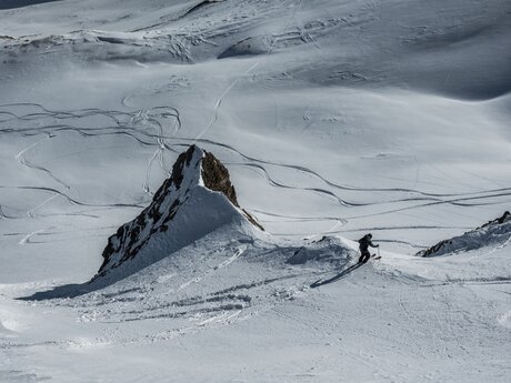  Skifahrer schneidet eine elegante Kurve in einen steilen, unberührten Hang | © Serfaus-Fiss-Ladis Marketing GmbH | Heli Düringer
