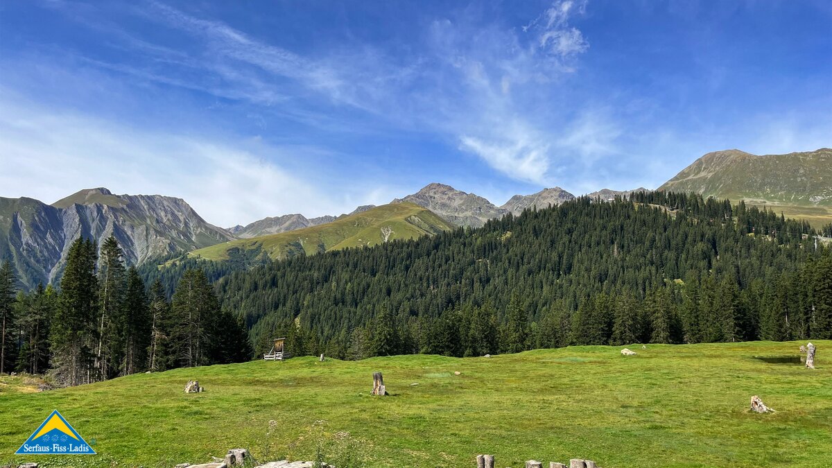Offene Landschaft mit grüner Wiese und weiter Sicht auf eine alpine Bergkette von Serfaus-Fiss-Ladis | © Serfaus-Fiss-Ladis Marketing GmbH