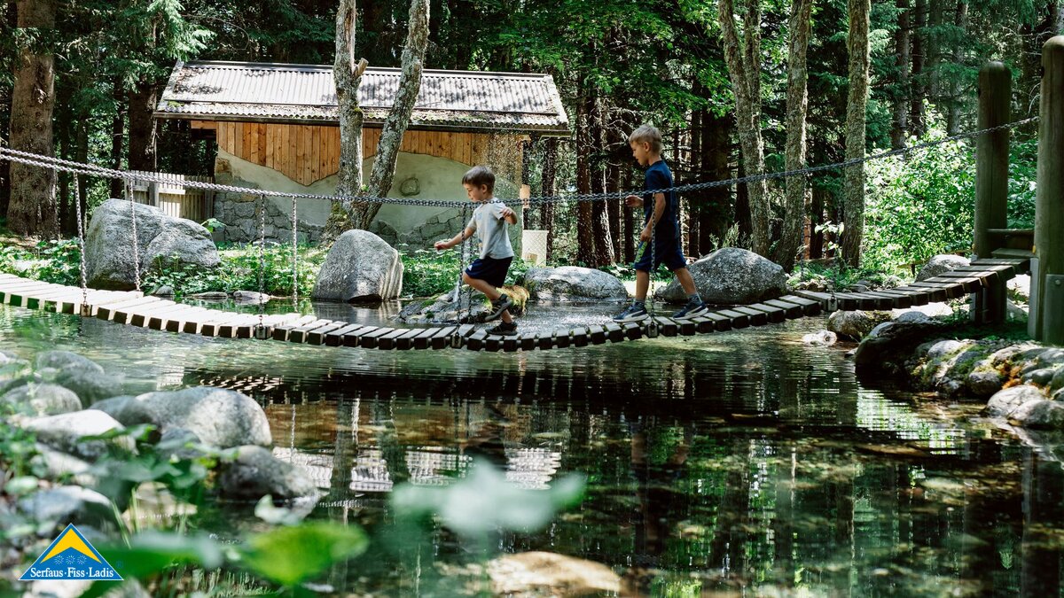 Kinder laufen über Brücke Teich Spielplatz Rabuschl Familienausflug mit Grillen in Serfaus Fiss Ladis in Tirol | © Serfaus-Fiss-Ladis Marketing GmbH | Rene Raggl