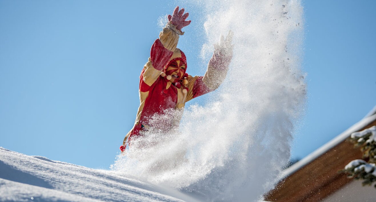 Der Bajatzl wirft Schnee auf die Besucher der Fisser Blochziehens | © Andreas Kirschner