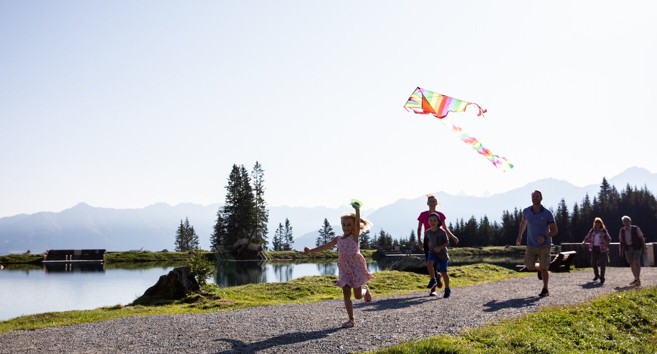 Der alpine Högsee in der Familienregion Serfaus-Fiss-Ladis in Tirol lädt zum Baden, Sonnenbaden und Spielen ein | © danielzangerl.com