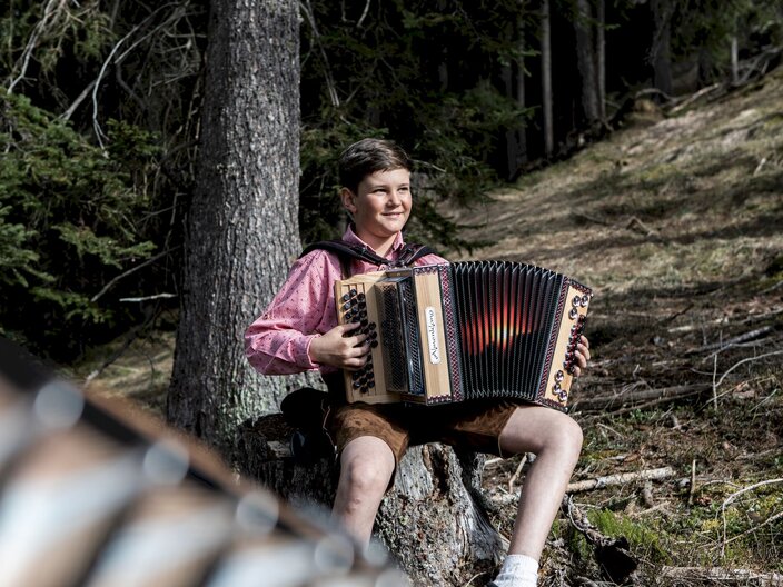 Elia Heiseler Ziehharmonika spielen Naturmusik Familienregion Serfaus-Fiss-Ladis Tirol | © Serfaus-Fiss-Ladis Marketing GmbH | Rene Raggl
