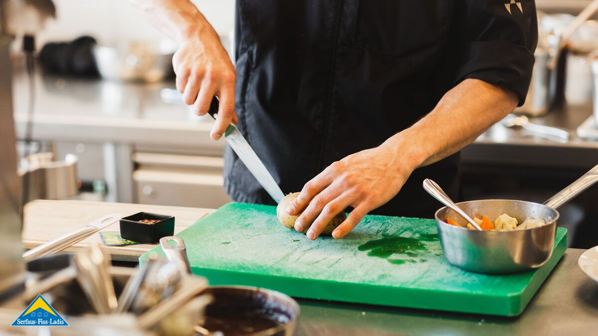 Koch in der Küche beim Gemüseschneiden Jobs Gastronomie Familienregion Serfaus-Fiss-Ladis in Tirol | © Fisser Bergbahnen GmbH | Manuel Pale