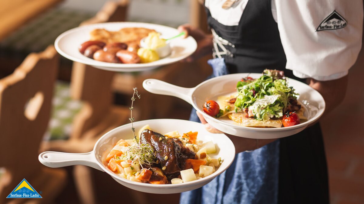 Keller serviert in der Zirbenhütte regionale Speisen Familienregion Serfaus-Fiss-Ladis in Tirol | © Fisser Bergbahnen GmbH | Manuel Pale