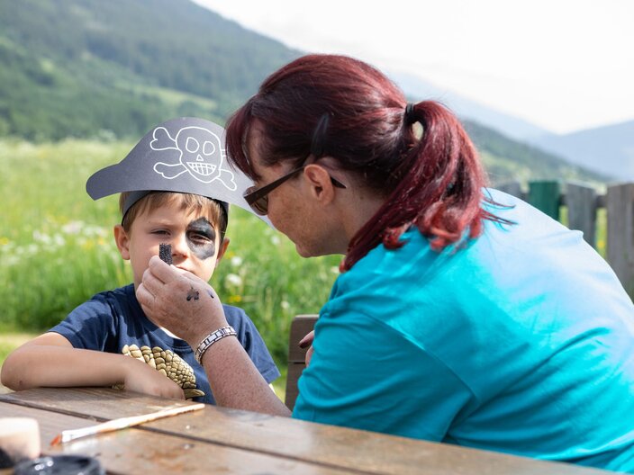 Kinderclubleiterin Cordula Geiger beim Schminken Kinderbetreuung im Sommerurlaub in Serfaus-Fiss-Ladis in Tirol | © Serfaus-Fiss-Ladis Marketing GmbH | Andreas Kirschner