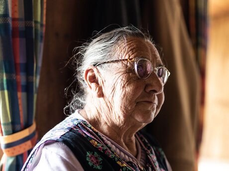 Alte Frau mit Brille und Kochschürze in einer alten Bauernstube Familienregion Serfaus-Fiss-Ladis in Tirol | © Serfaus-Fiss-Ladis Marketing GmbH | Rene Raggl