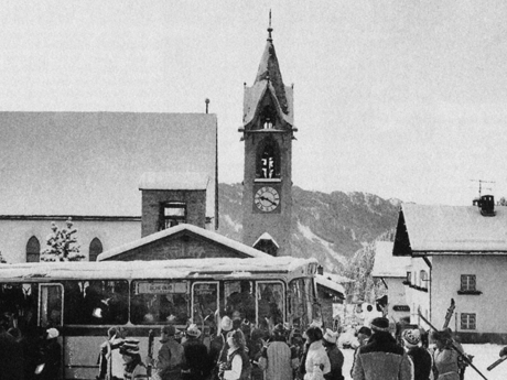 Ein nostalgisches Bild mit der Kirche und einem Skibus aus dem Bergdorf Serfaus | © Serfaus-Fiss-Ladis Marketing GmbH | Andreas Kirschner