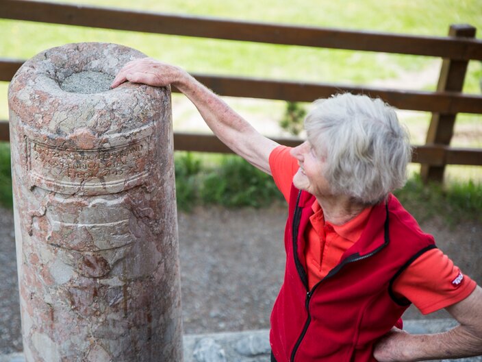 Die Seniorchefin des Tiroler Sauerbrunns Burgl bei der roten Marmorsäule welche Erzherzog Ferdinand II errichten ließ | © Socialweb