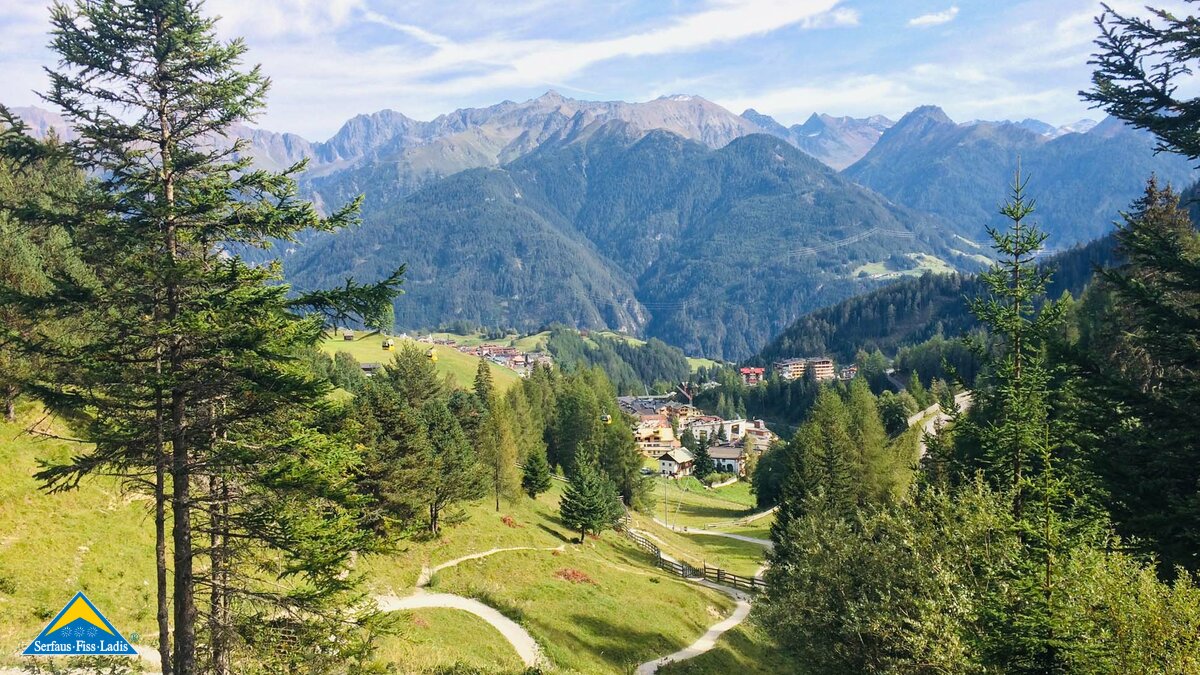 Der Blick durch die Bäume auf das Dorf Serfaus im Tiroler Oberland in Österreich | © Serfaus-Fiss-Ladis