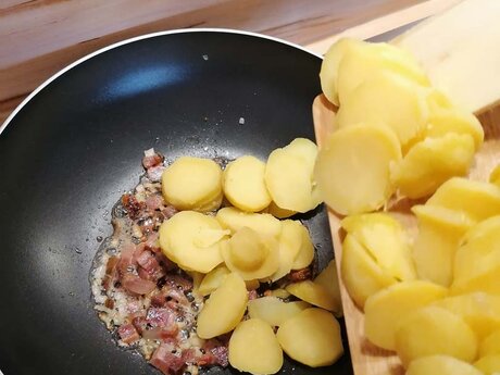 Für das Tiroler Gröstl aus Serfaus Fiss Ladis in Tirol Österreich müssen Kartoffeln in Scheiben geschnitten und in die heiße Pfanne gegeben werden | © Serfaus-Fiss-Ladis