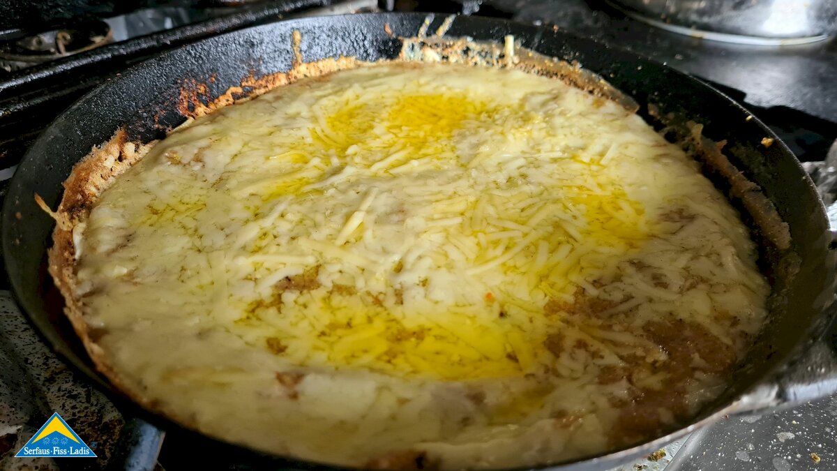 Zubereitung Bauerrnessen in der Pfanne Kasmuas Käse sinkt auf den Pfannenboden Rezept Restaurant Madatschen Serfaus-Fiss-Ladis in Tirol | © Serfaus-Fiss-Ladis Marketing GmbH
