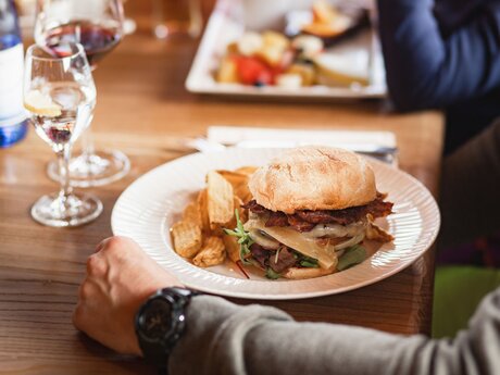 Grauvieh Burger essen in der Zirbenhütte im Skigebiet Serfaus-Fiss-Ladis in Tirol | © Fisser Bergbahnen GmbH | Manuel Pale