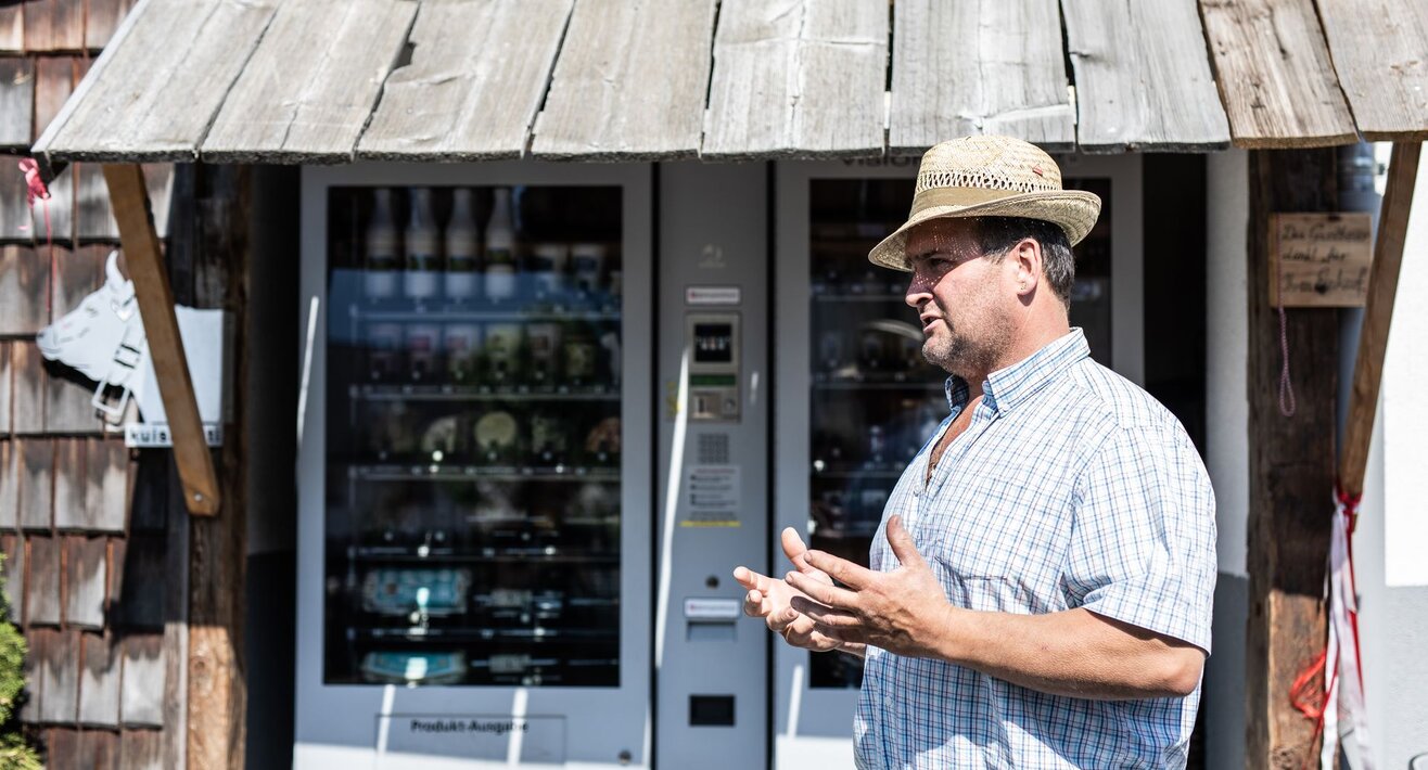 Bauer Hans Pittl vor seinen zwei Automaten mit regionalen Produkten in Ladis in Tirol | © Serfaus-Fiss-Ladis Marketing GmbH | Rene Raggl