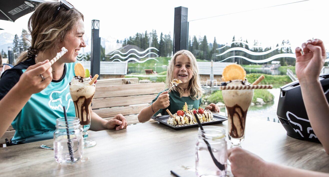 Kind isst mit Familie Eis auf einer Terrasse Bergrestaurant Sonnenburg Sommerurlaub in Serfaus-Fiss-Ladis Tirol | © Serfaus-Fiss-Ladis Marketing GmbH | Rene Raggl