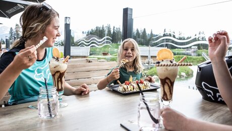Kind isst mit Familie Eis auf einer Terrasse Bergrestaurant Sonnenburg Sommerurlaub in Serfaus-Fiss-Ladis Tirol | © Serfaus-Fiss-Ladis Marketing GmbH | Rene Raggl