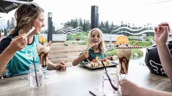 Kind isst mit Familie Eis auf einer Terrasse Bergrestaurant Sonnenburg Sommerurlaub in Serfaus-Fiss-Ladis Tirol | © Serfaus-Fiss-Ladis Marketing GmbH | Rene Raggl