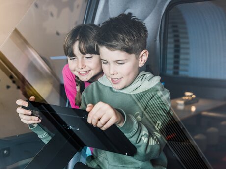 Kinder in der Mittagspause im Skiurs beim Spielen am Ipad Kinderrestaurant Starrest Blogbeitrag | © Serfaus-Fiss-Ladis Marketing GmbH | Fabian Schirgi