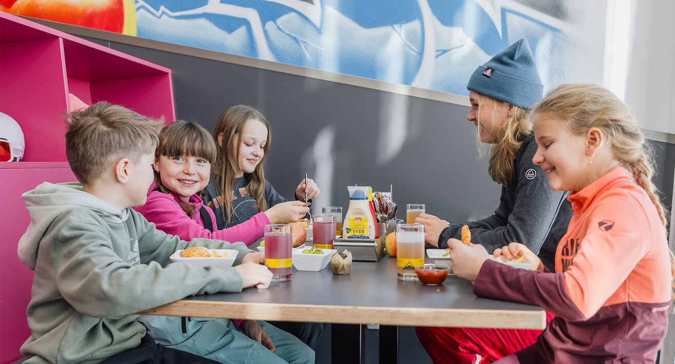Skilehrerin der Skischule Serfaus beim Mittagessen mit ihrer Gruppe im Kinderrestaurant Starrest Skiurlaub Serfaus-Fiss-Ladis Tirol | © Serfaus-Fiss-Ladis Marketing GmbH | Fabian Schirgi