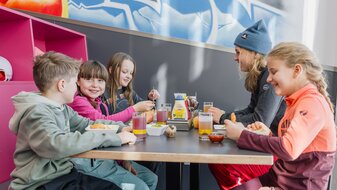 Skilehrerin der Skischule Serfaus beim Mittagessen mit ihrer Gruppe im Kinderrestaurant Starrest Skiurlaub Serfaus-Fiss-Ladis Tirol | © Serfaus-Fiss-Ladis Marketing GmbH | Fabian Schirgi
