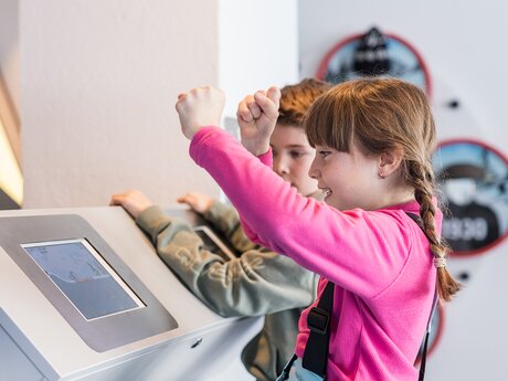 Zwei Kinder sitzen am Tablet und spielen Mittagspause im Kinderrestaurant Starrest Erfahrungsbericht Blog Serfaus-Fiss-Ladis | © Serfaus-Fiss-Ladis Marketing GmbH | Fabian Schirgi