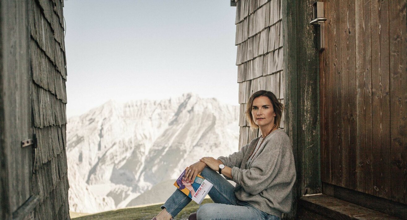 Autorin Monika Schmiderer mit ihrem Buch Switch off in den Bergen von Serfaus-Fiss-Ladis in Tirol | © Mike Rabensteiner