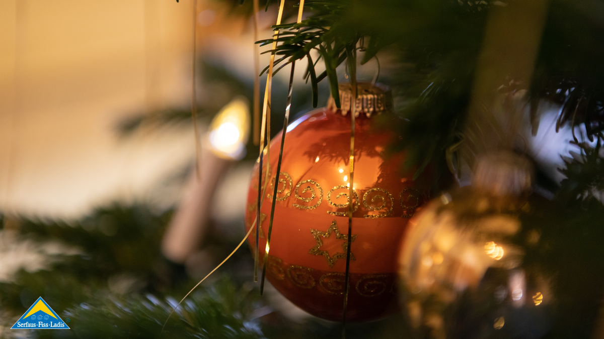 Orange leuchtende Christbaumkugel auf einem Tannenzweig | © Andreas Kirschner