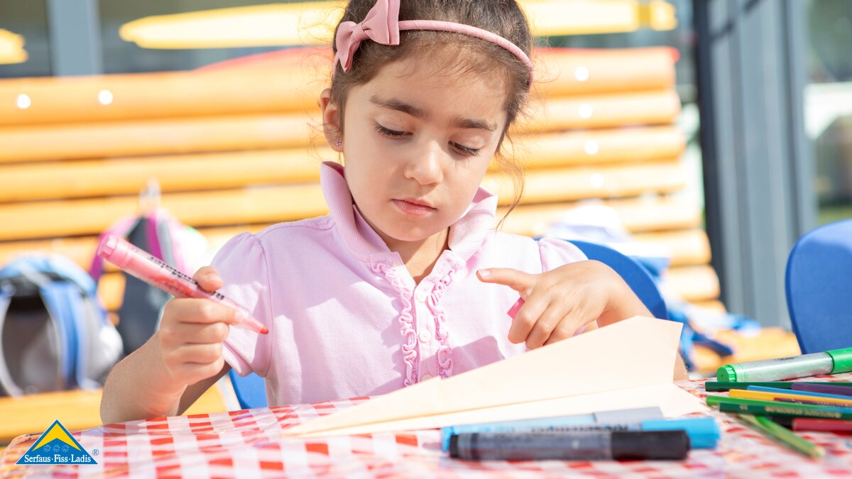 Mädchen beim Malen vor dem Kinderclubs Mini&Maxi Club beim Kulturhaus in Fiss | © Serfaus-Fiss-Ladis Marketing GmbH | Andreas Kirschner