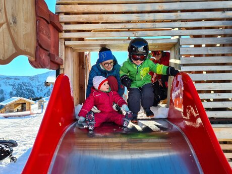 Rutschen  mit Kleinkindern in der Kinderschneealm am Komperdell Skigebiet Serfaus-Fiss-Ladis in Tirol | © Serfaus-Fiss-Ladis Marketing GmbH